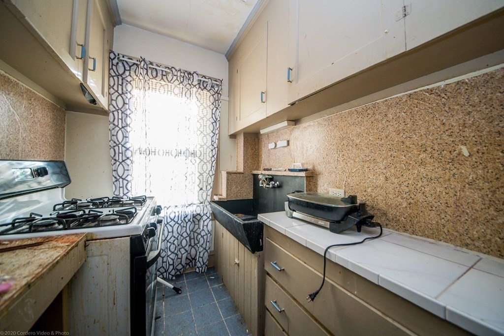 139 Jackson Street Fall River, MA 02721 - Photo 13 of 22 a kitchen with a sink and a stove top oven