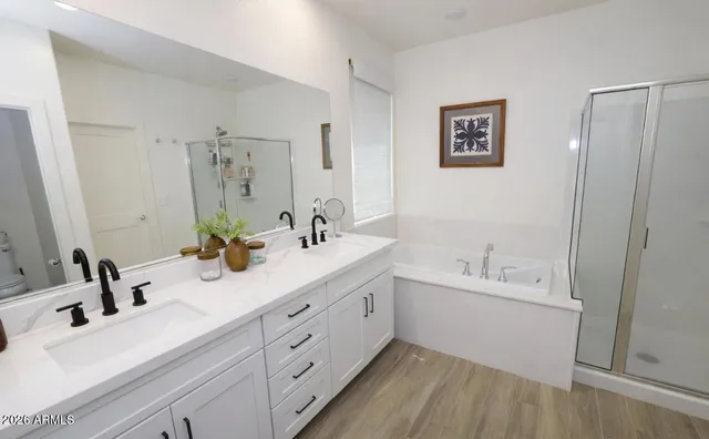 a bathroom with a double vanity sink mirror and bathtub