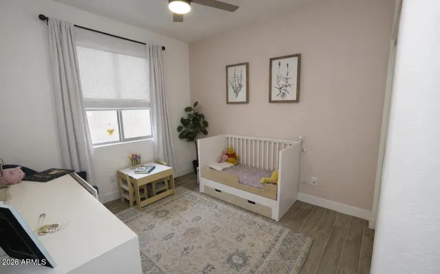 a view of a bedroom with baby crib and a window