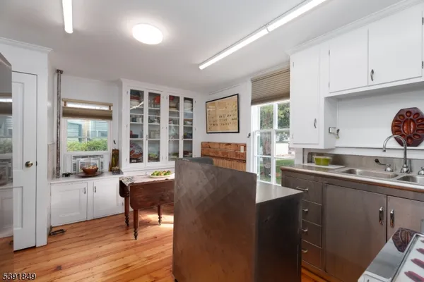 a living room with furniture a large window and wooden floor
