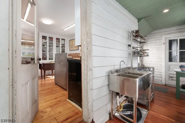 a kitchen with stainless steel appliances kitchen island granite countertop a table chairs in it and wooden floors