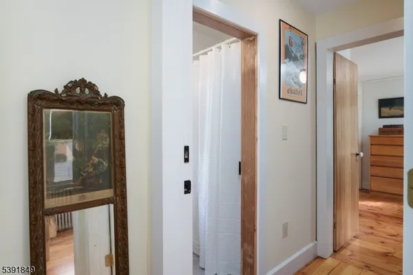 a view of a hallway with wooden floor and closet