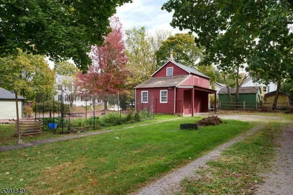 a front view of a house with a garden and trees