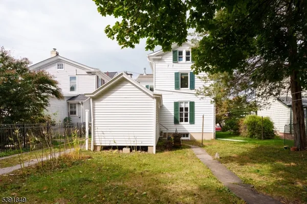 a view of a house with backyard and trees