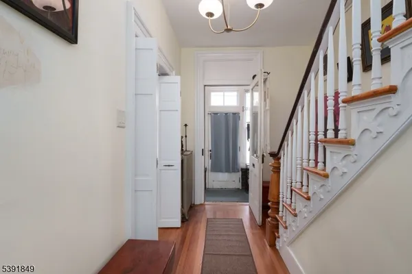 a view of hallway with wooden floor and stairs