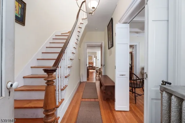 a view of a hallway with wooden floor and staircase