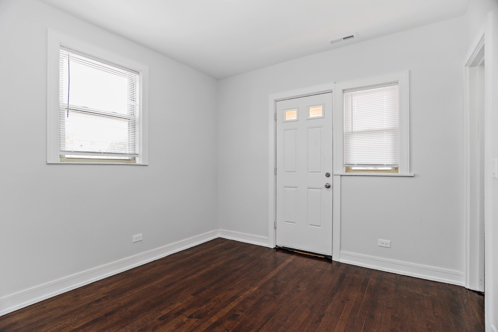 4313 West Parker Avenue Chicago, IL 60639 - Photo 11 of 17 an empty room with wooden floor and windows