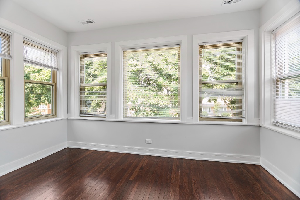 4313 West Parker Avenue Chicago, IL 60639 - Photo 13 of 17 a view of an empty room with wooden floor and a window