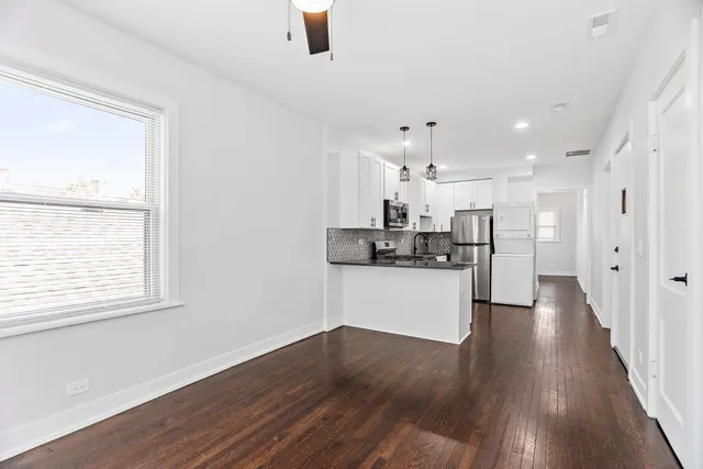 a kitchen with stainless steel appliances refrigerator wooden floor and window