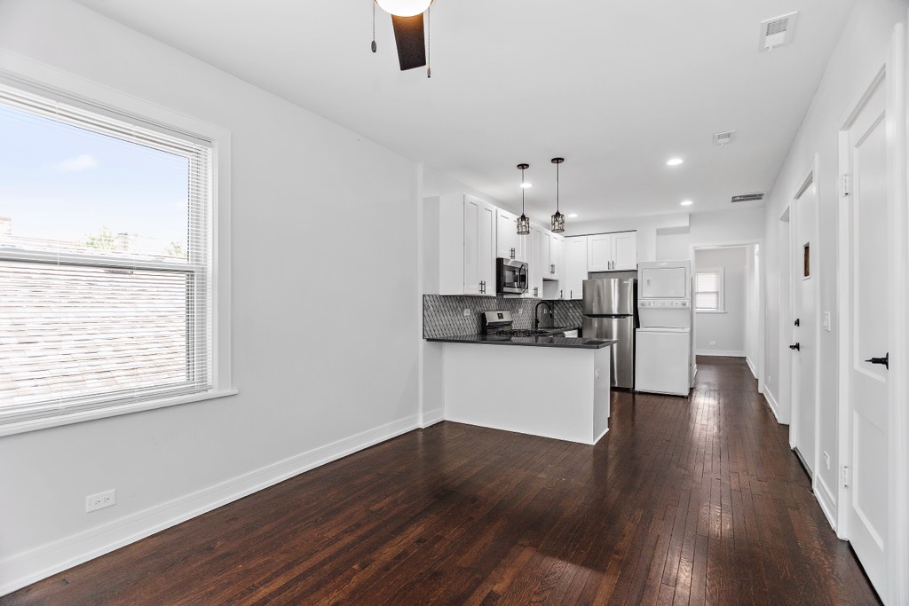 4313 West Parker Avenue Chicago, IL 60639 - Photo 2 of 17 a kitchen with stainless steel appliances refrigerator wooden floor and window