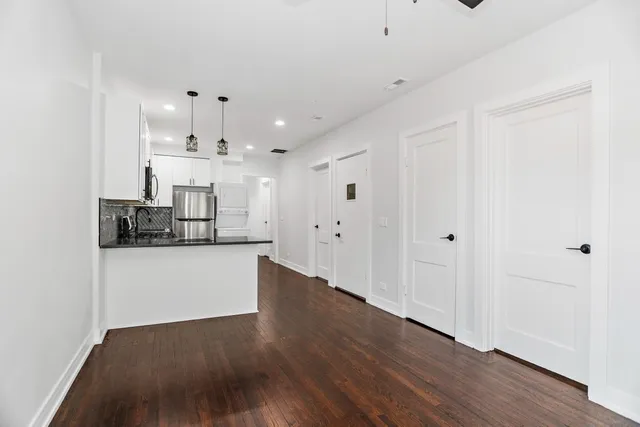 a view of a kitchen with wooden floor and cabinets