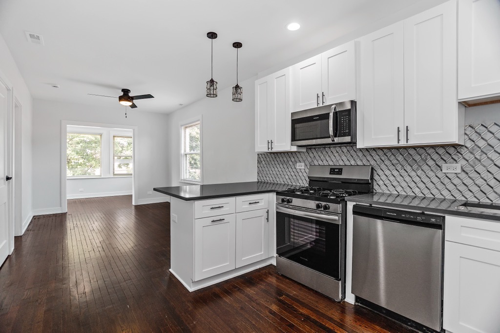4313 West Parker Avenue Chicago, IL 60639 - Photo 6 of 17 a kitchen with a stove a sink and a microwave