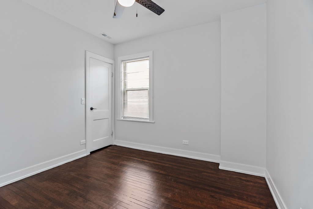 4313 West Parker Avenue Chicago, IL 60639 - Photo 7 of 17 an empty room with wooden floor and windows