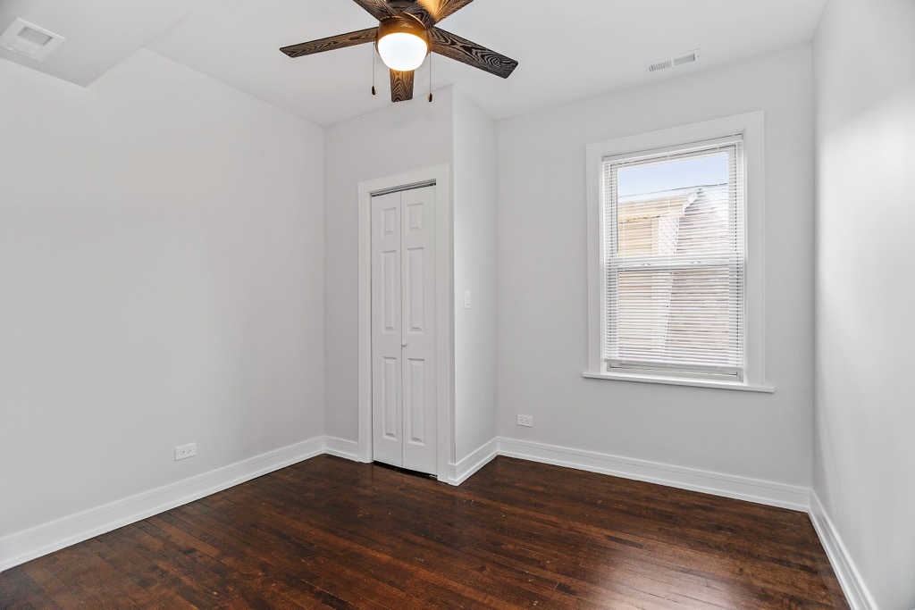 4313 West Parker Avenue Chicago, IL 60639 - Photo 9 of 17 an empty room with wooden floor fan and windows