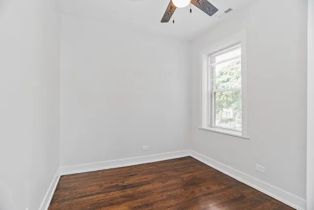 an empty room with a window and wooden floor
