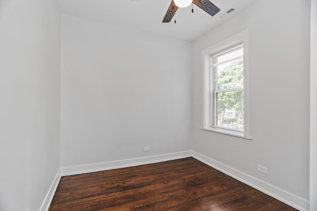 4313 West Parker Avenue Chicago, IL 60639 - Photo 10 of 17 an empty room with a window and wooden floor