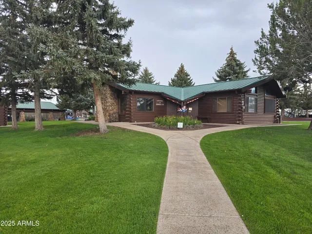 a front view of house with a garden and trees