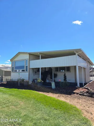 a view of a house with a backyard and a tree