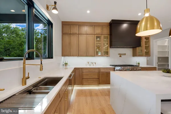 a kitchen with kitchen island a sink appliances cabinets and a counter top space