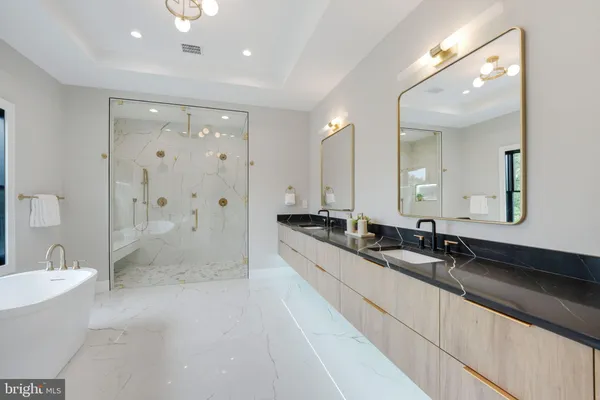 a large white bathroom with a granite countertop sink and mirror