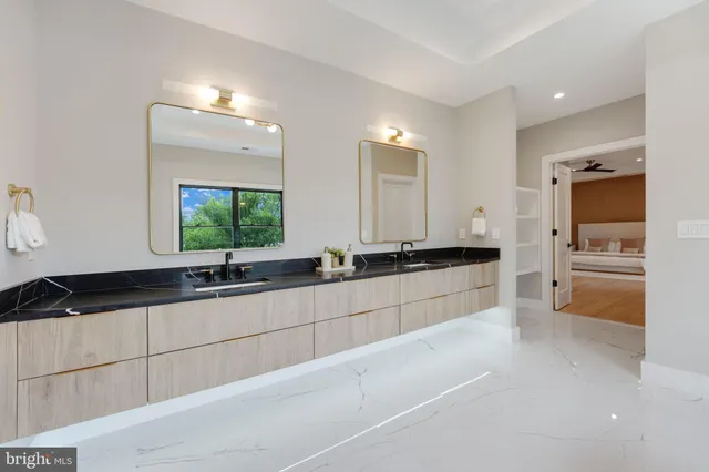 a bathroom with a granite countertop toilet sink and mirror