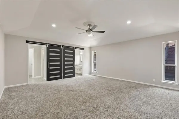 an empty room with closet and a ceiling fan