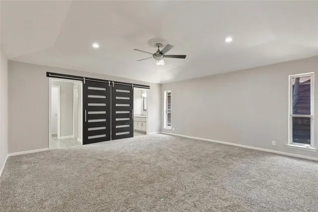 an empty room with closet and a ceiling fan
