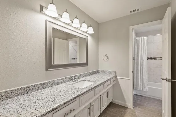 a bathroom with a granite countertop sink and a mirror