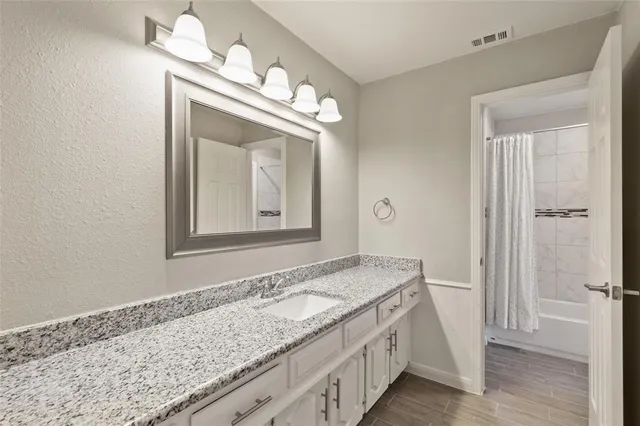 a bathroom with a granite countertop sink and a mirror
