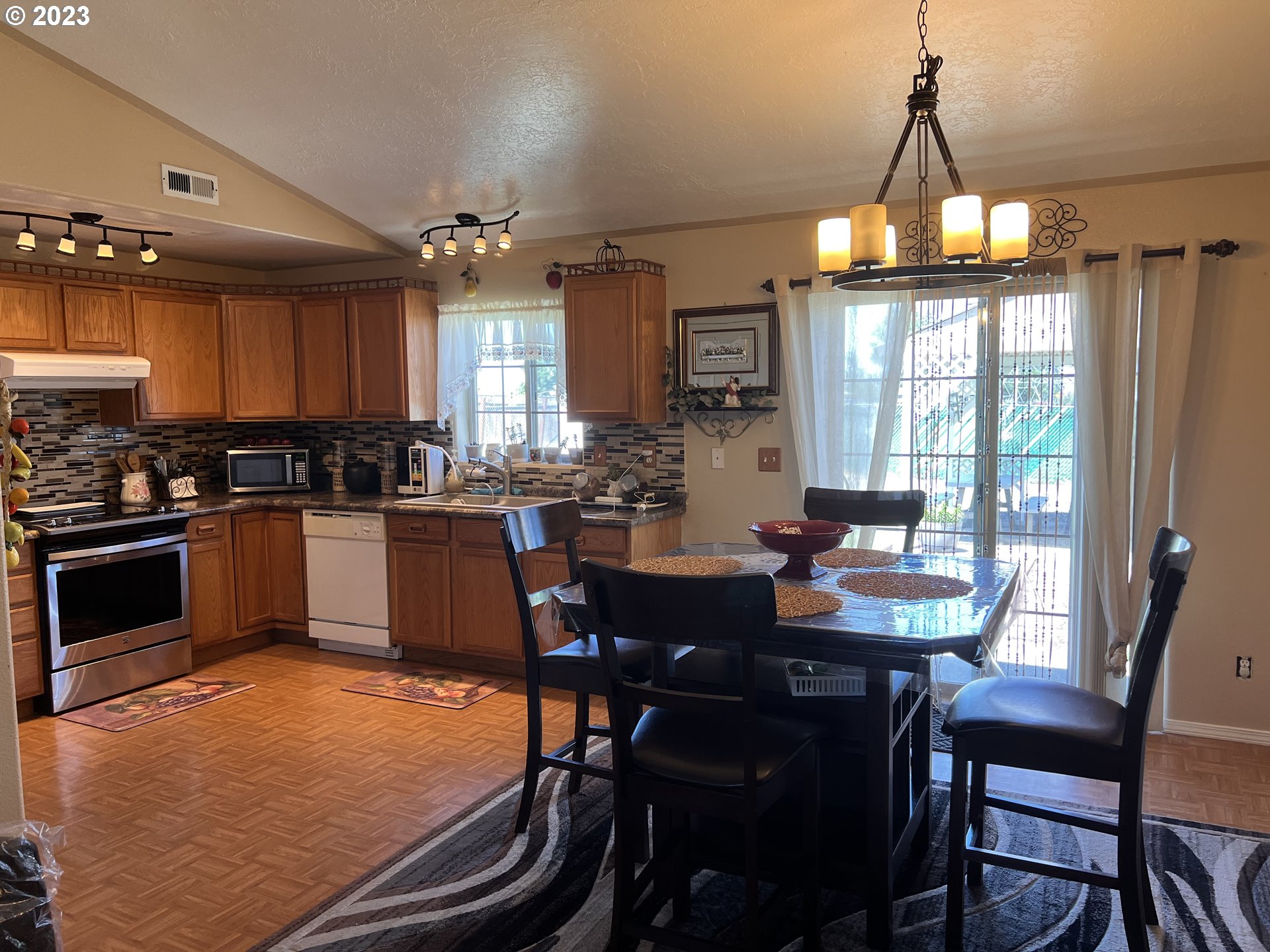 155 Pine Tree Avenue Umatilla, OR 97882 - Photo 5 of 15 a kitchen with a dining table chairs and white cabinets