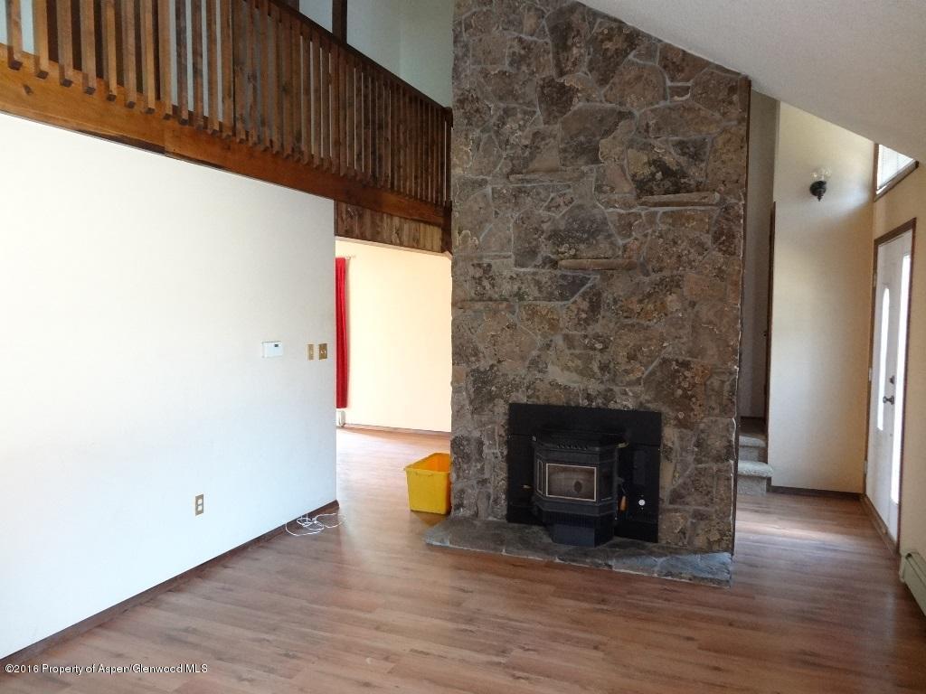 416 Will Avenue Rifle, CO 81650 - Photo 2 of 14 a view of an empty room with wooden floor and a fireplace