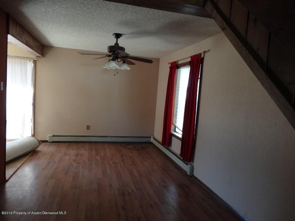 416 Will Avenue Rifle, CO 81650 - Photo 3 of 14 a view of a hallway with wooden floor and a chandelier