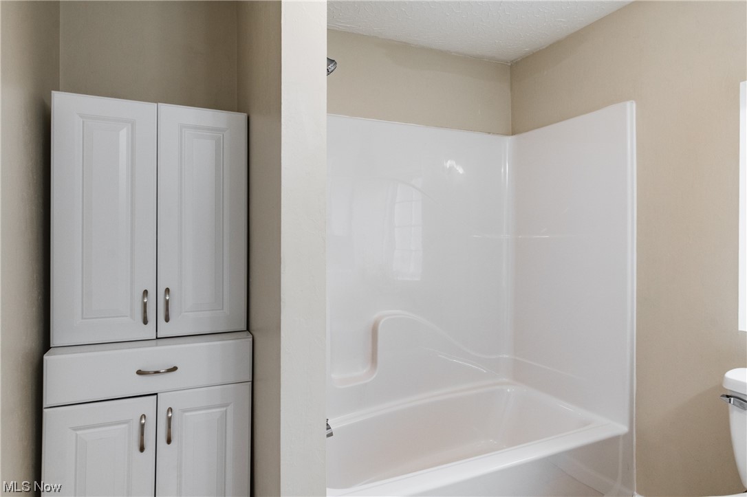 2815 Sealy Ridge Road Vincent, OH 45784 - Photo 12 of 21 Bathroom featuring tub / shower combination, a textured ceiling, and toilet