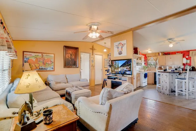 a living room with furniture kitchen view and a large window