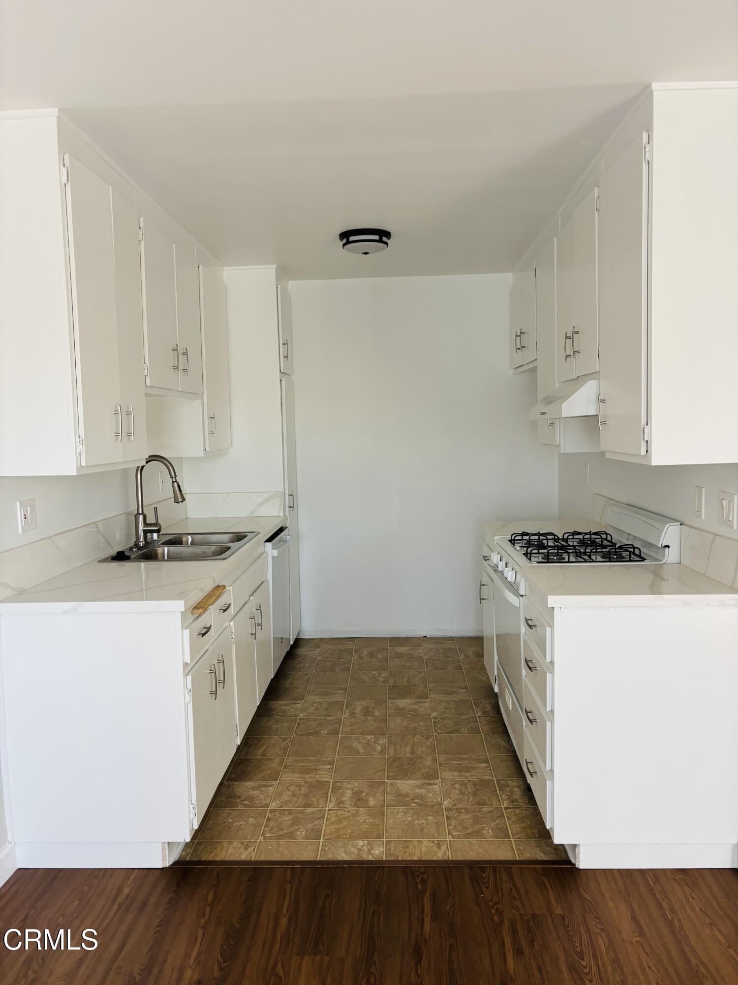 2750 Piedmont Avenue, Unit 22 Montrose, CA 91020 - Photo 1 of 10 a kitchen with a stove and white cabinets