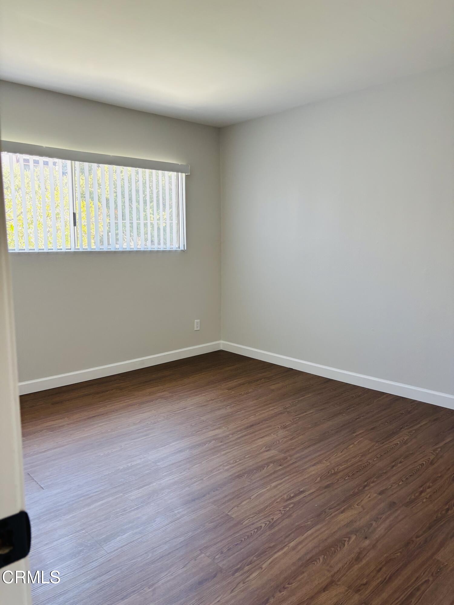 2750 Piedmont Avenue, Unit 22 Montrose, CA 91020 - Photo 5 of 10 a view of an empty room with wooden floor and a window