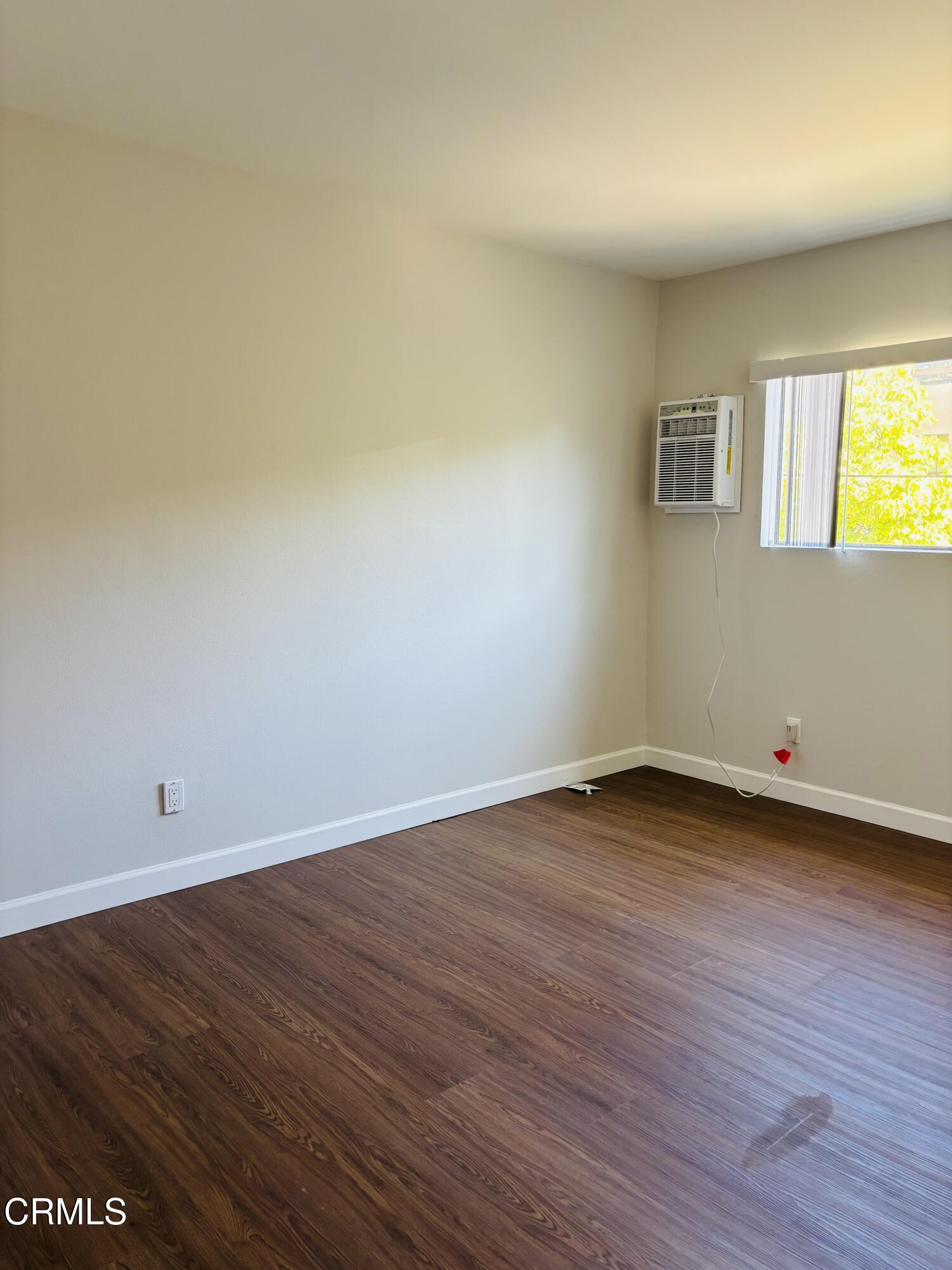 2750 Piedmont Avenue, Unit 22 Montrose, CA 91020 - Photo 6 of 10 a view of an empty room with wooden floor and a window