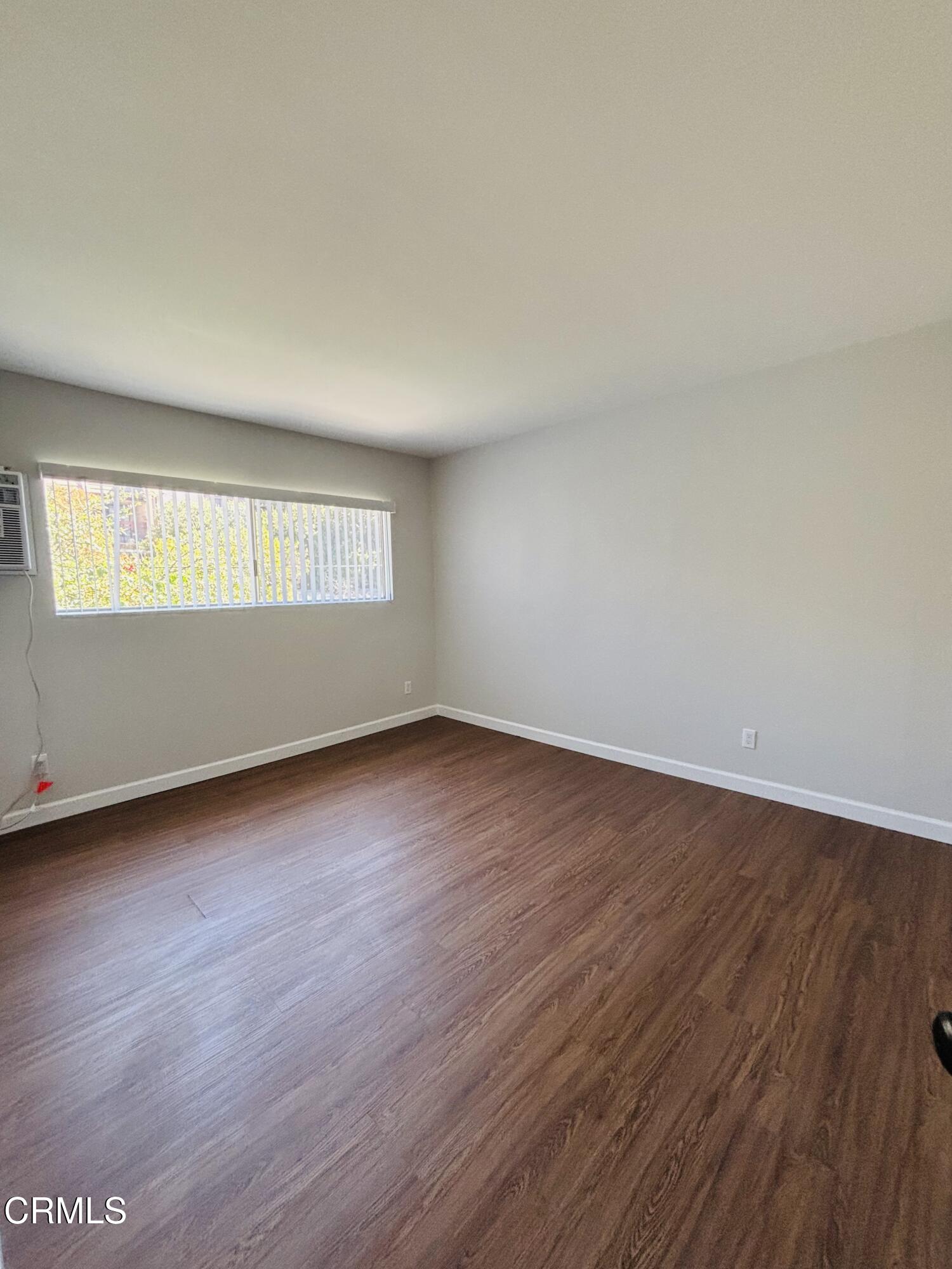 2750 Piedmont Avenue, Unit 22 Montrose, CA 91020 - Photo 8 of 10 an empty room with wooden floor and windows