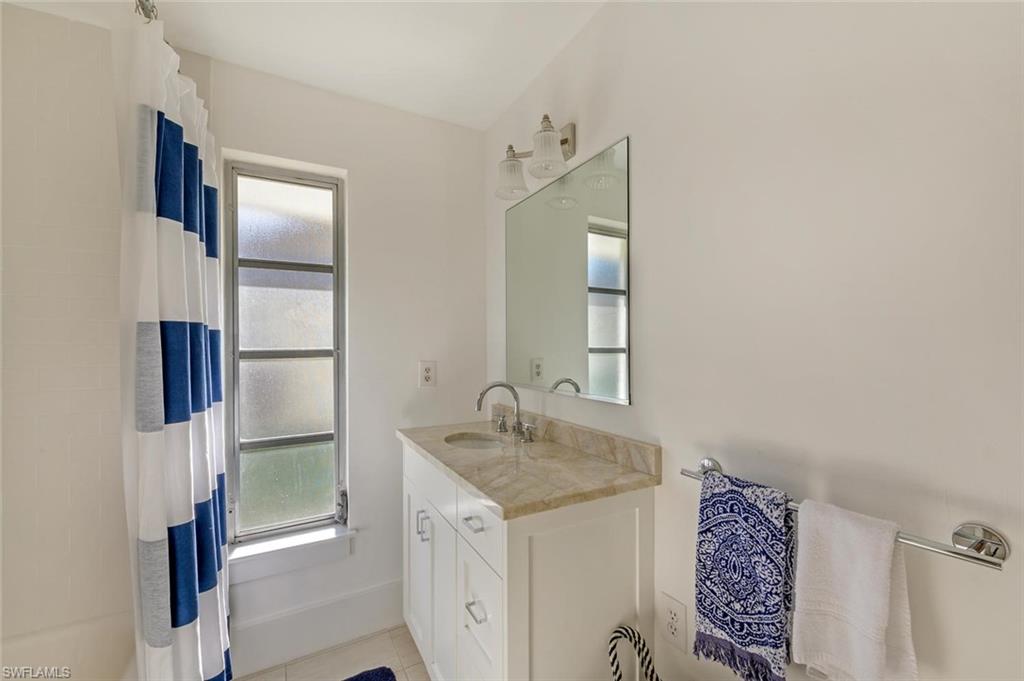 239 Torrey Pines Point Naples, FL 34113 - Photo 31 of 36 a bathroom with a granite countertop sink and a mirror