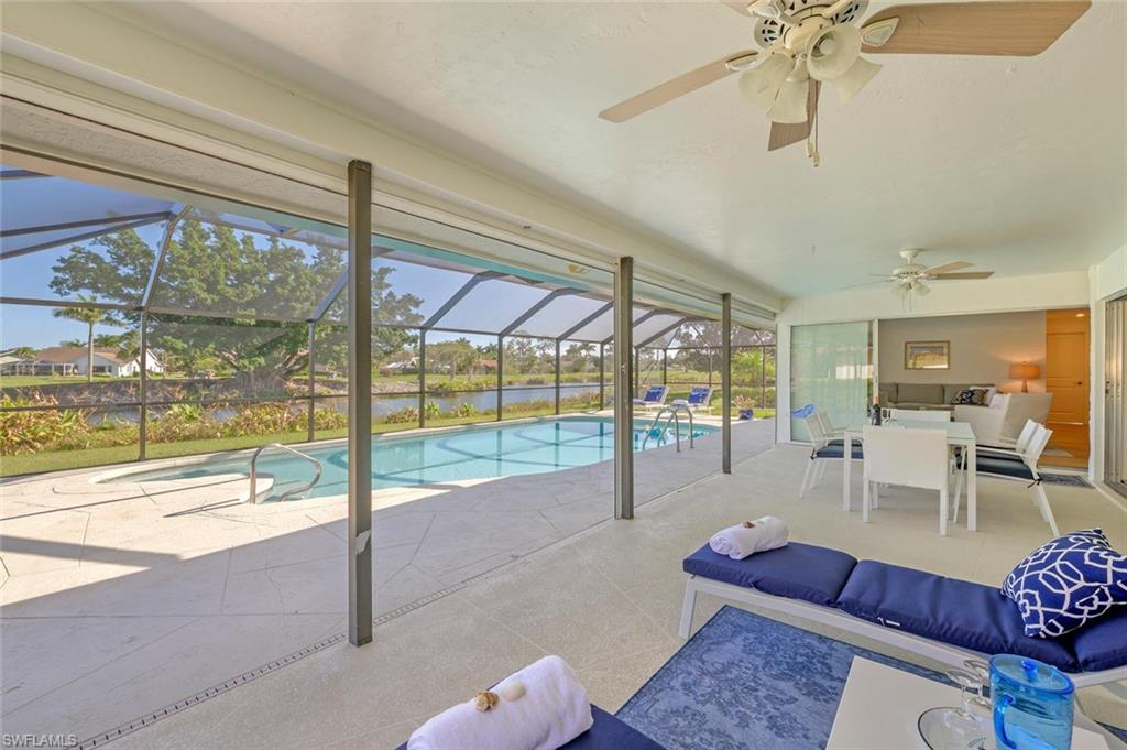 239 Torrey Pines Point Naples, FL 34113 - Photo 4 of 36 a living room with furniture and a floor to ceiling window