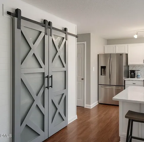 a kitchen with a refrigerator a microwave and wooden floor