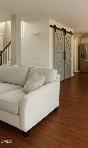 a living room with furniture and a wooden floor