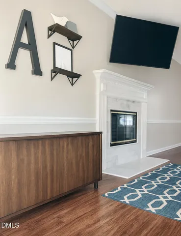 a living room with a fireplace and wooden floor