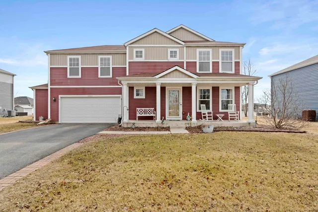 a view of a brick house with large windows and a yard