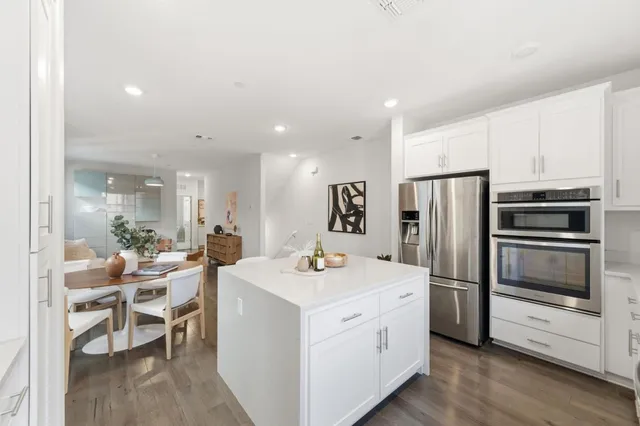 a kitchen with white cabinets and stainless steel appliances