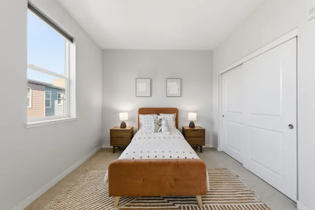 a bed sitting in a bedroom next to a window