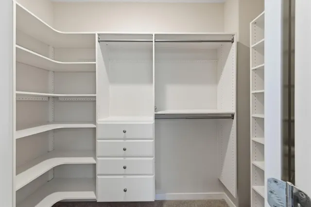 a view of walk in closet with empty racks