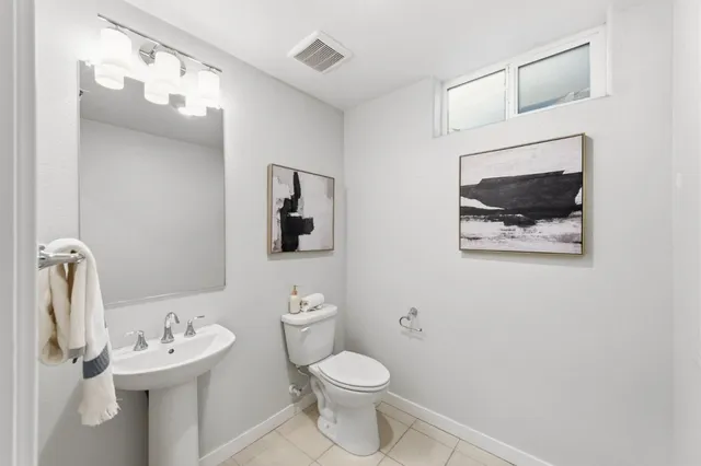 a bathroom with a sink mirror and toilet