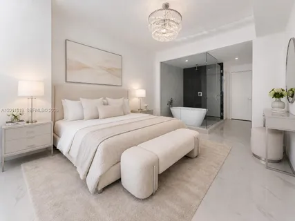 a bedroom with a bed and a chandelier
