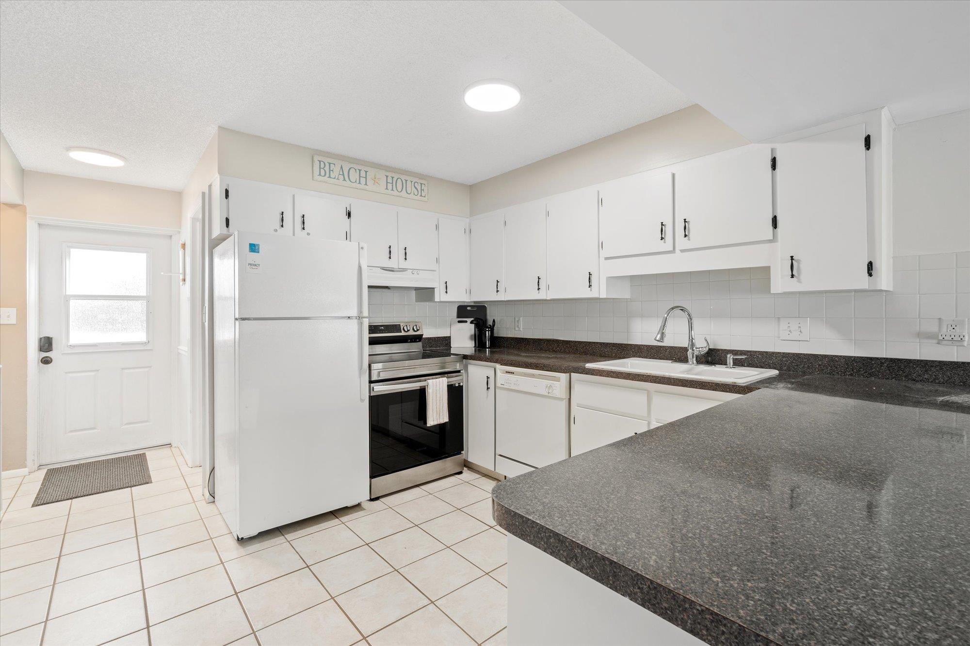 1 Ocean Trace Road, Unit 242 St. Augustine, FL 32080 - Photo 4 of 66 a kitchen with white cabinets and white appliances